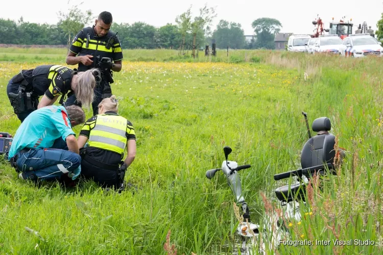 Man met scootmobiel te water in Egmond aan den Hoef